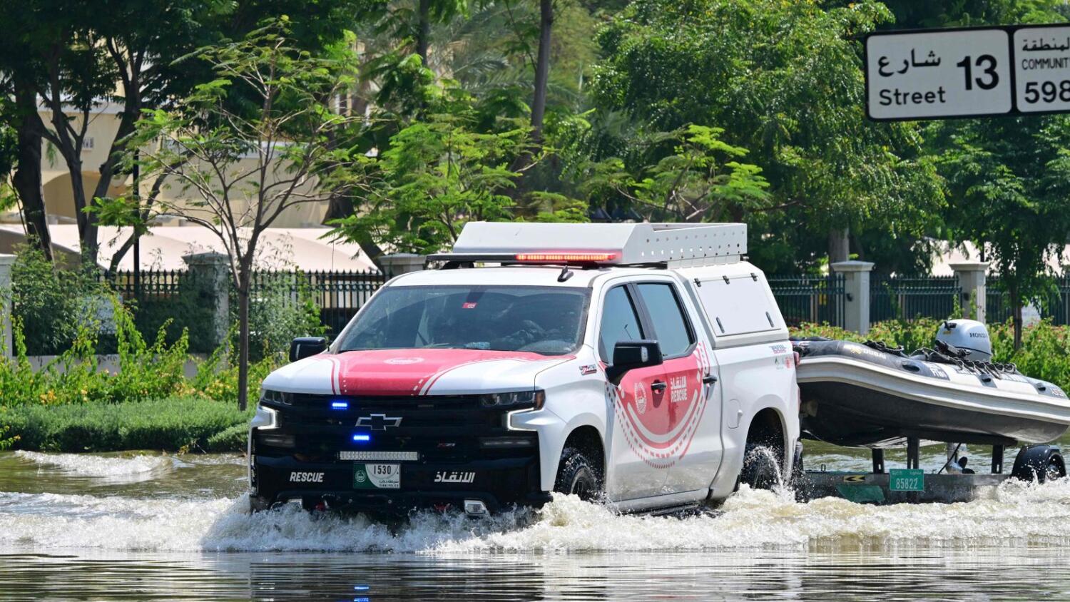 A Dubai Police car pulls a speed boat in a flooded street following heavy rains. Photo: AFP file